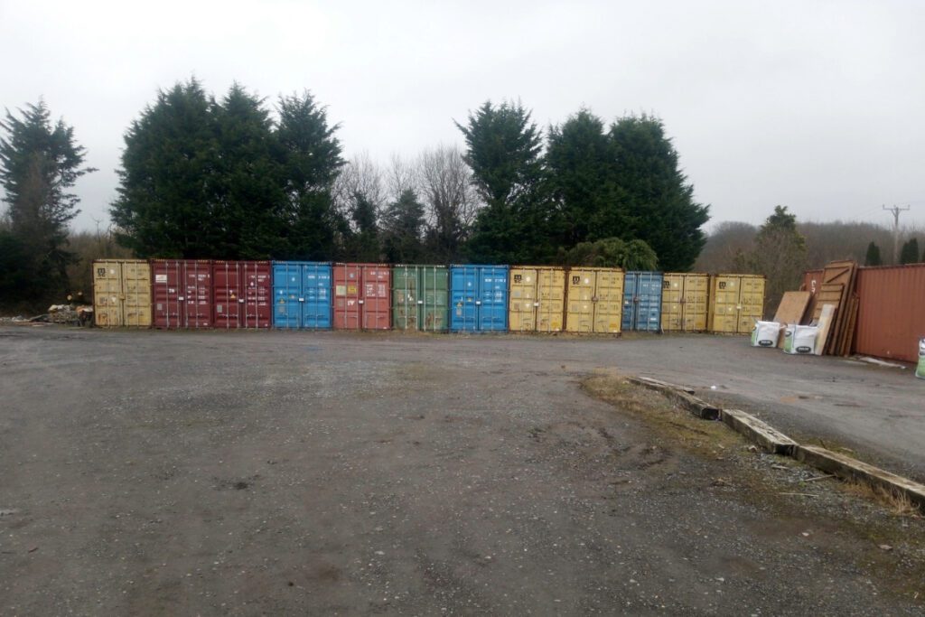 A row of hired storage containers at a garden centre.